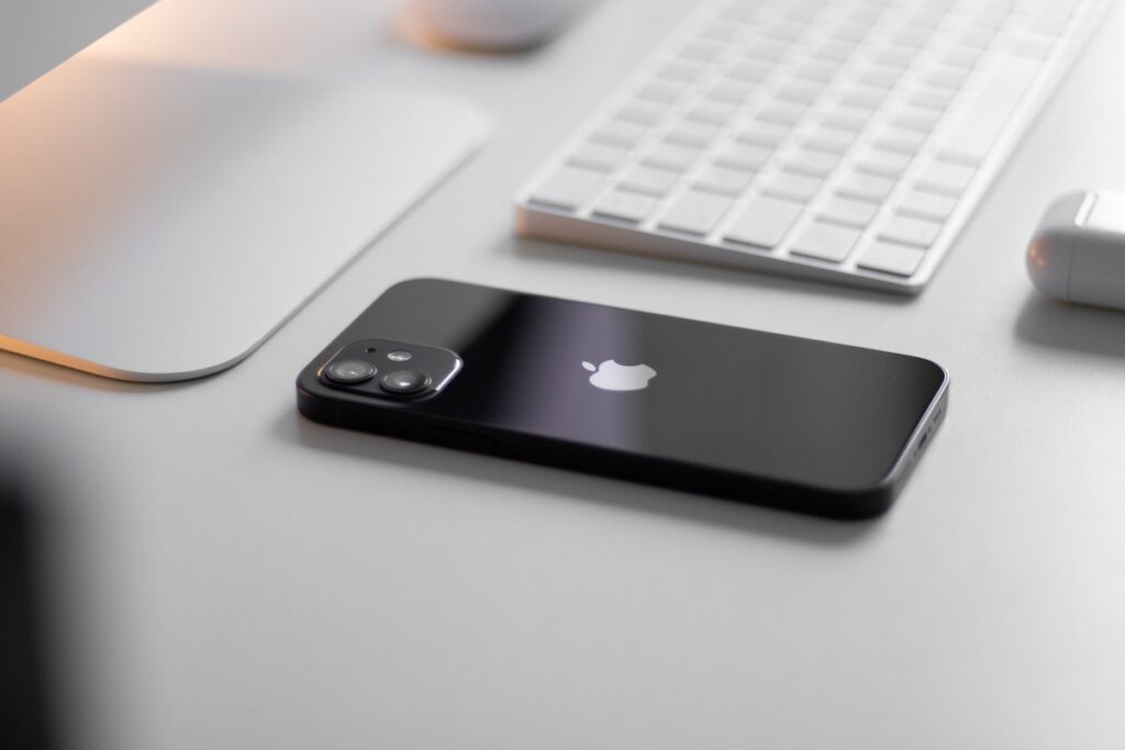 Schwarzes iPhone auf einem Schreibtisch